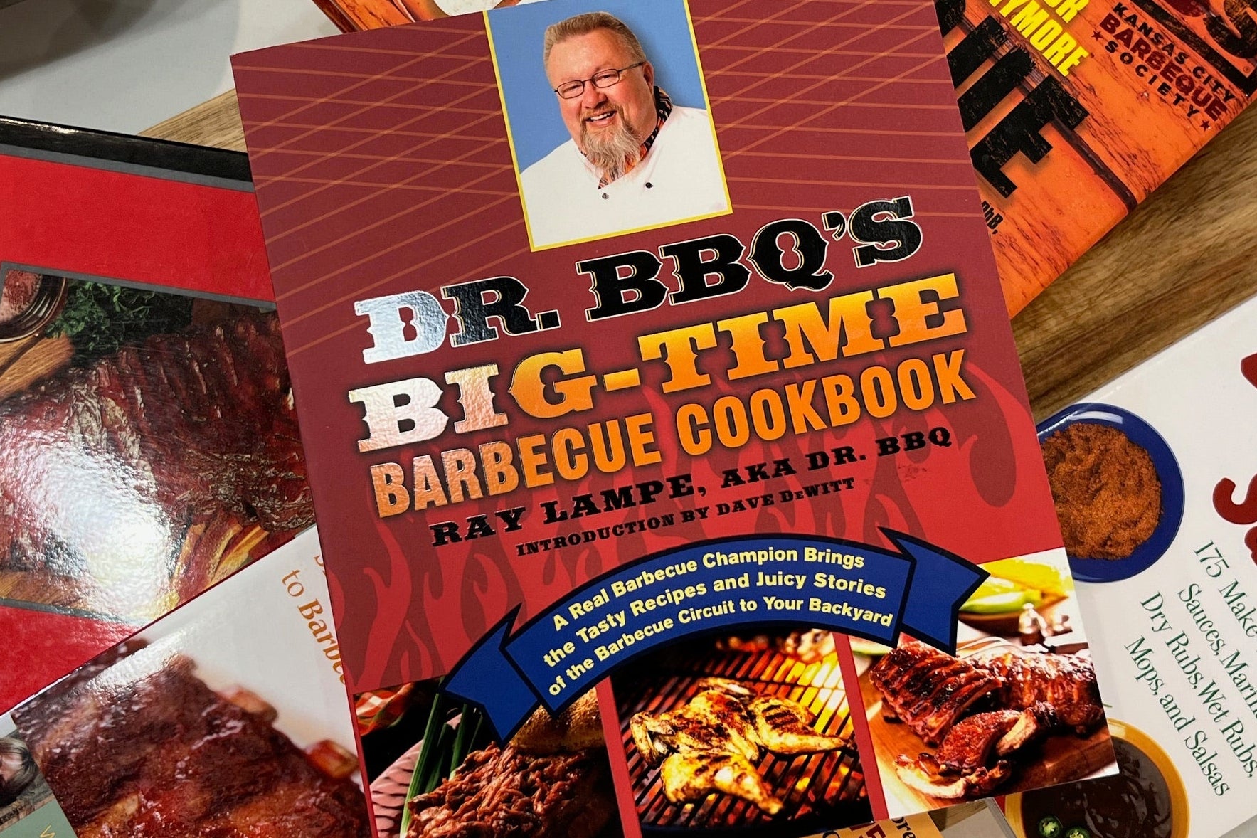 Dr. BBQ's Big-Time Barbecue Cookbook on a table with other cookbooks.