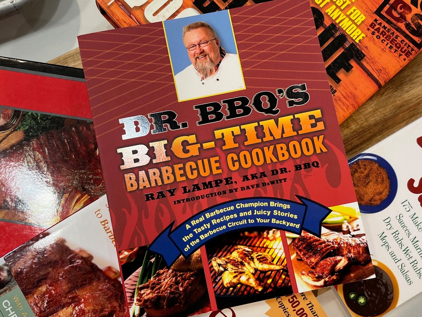 Dr. BBQ's Big-Time Barbecue Cookbook on a table with other cookbooks.